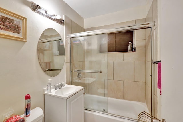 full bathroom with toilet, combined bath / shower with glass door, and vanity