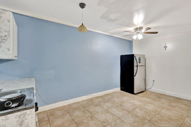 kitchen with stainless steel refrigerator, ceiling fan, white cabinets, pendant lighting, and light tile patterned floors