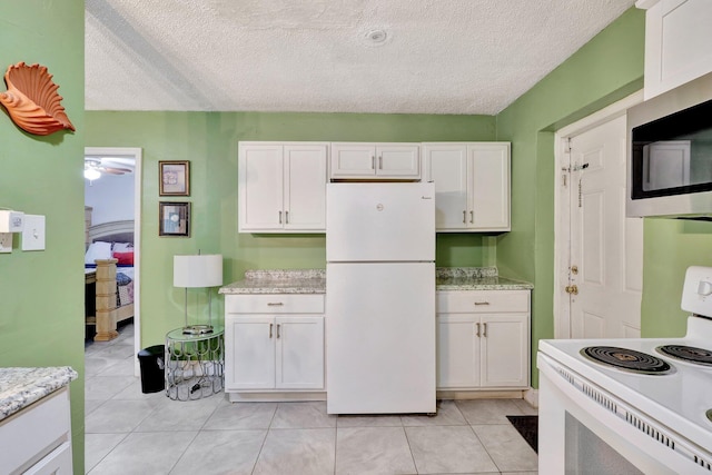 kitchen featuring white cabinets, a textured ceiling, white appliances, and ceiling fan