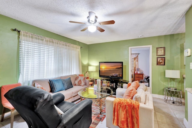 living room featuring ceiling fan, light tile patterned floors, and a textured ceiling