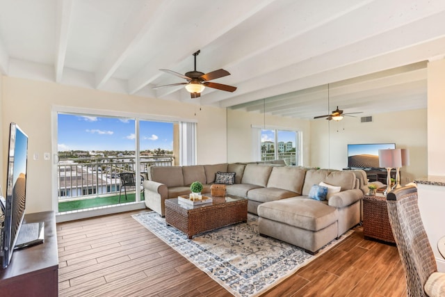 living room with ceiling fan, beam ceiling, and a water view