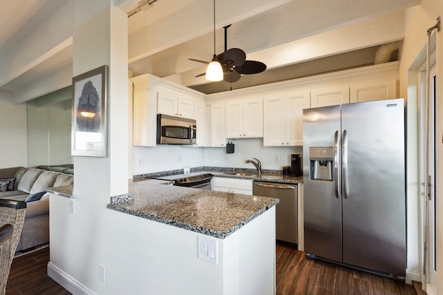 kitchen featuring appliances with stainless steel finishes, ceiling fan, sink, dark stone countertops, and white cabinetry