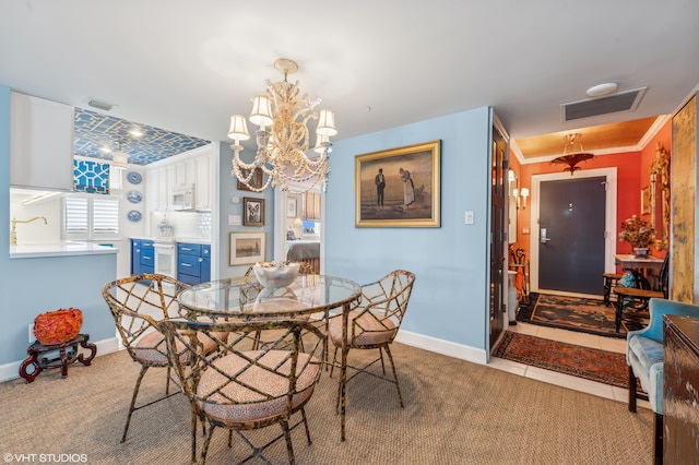 dining space with ornamental molding, light colored carpet, and a notable chandelier