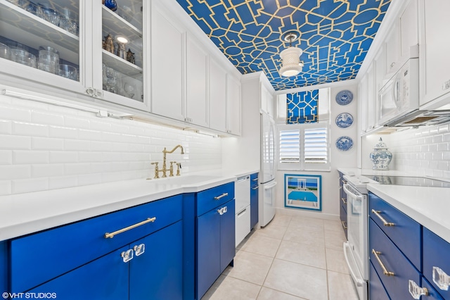 kitchen with blue cabinetry, white cabinetry, white appliances, and sink