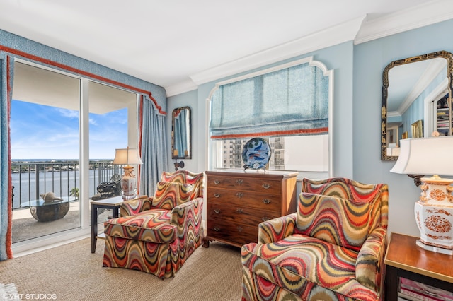 sitting room with carpet flooring, a water view, and ornamental molding