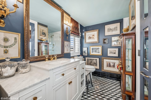 bathroom with vanity, toilet, and a shower with door