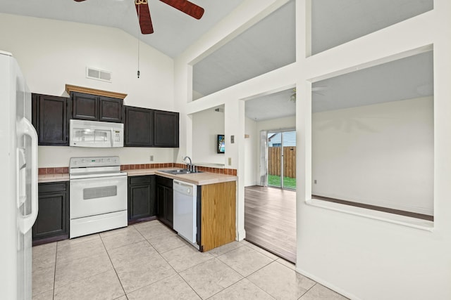 kitchen featuring white appliances, lofted ceiling, sink, ceiling fan, and light tile patterned floors