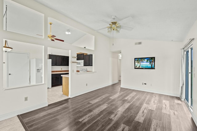 unfurnished living room with ceiling fan, light hardwood / wood-style flooring, and lofted ceiling