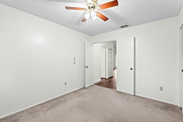 unfurnished bedroom with ceiling fan, carpet, and a textured ceiling