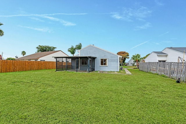 back of property with a sunroom and a lawn