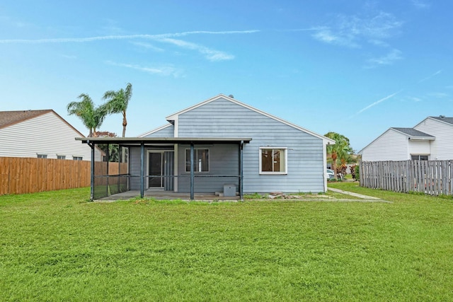 back of property with a yard and a sunroom