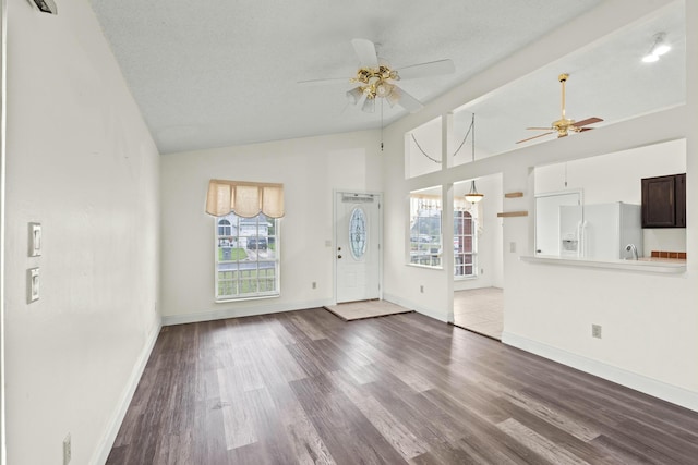 unfurnished living room with a textured ceiling, hardwood / wood-style flooring, and vaulted ceiling