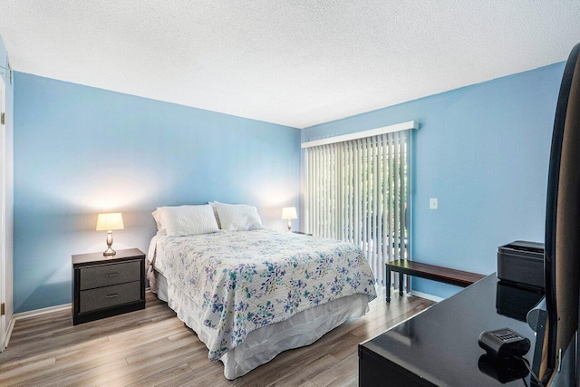 bedroom with light hardwood / wood-style flooring and a textured ceiling