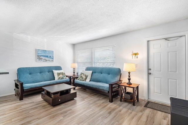 living room with a textured ceiling and light wood-type flooring