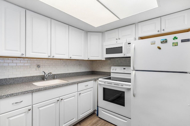 kitchen with white cabinetry, sink, and white appliances