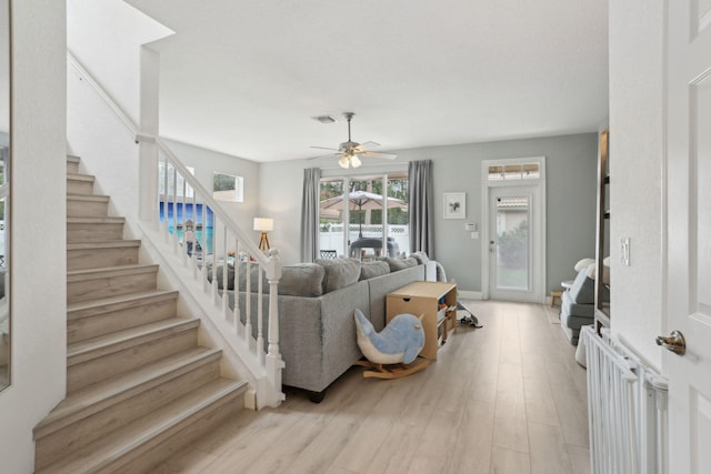 living room featuring ceiling fan and light wood-type flooring