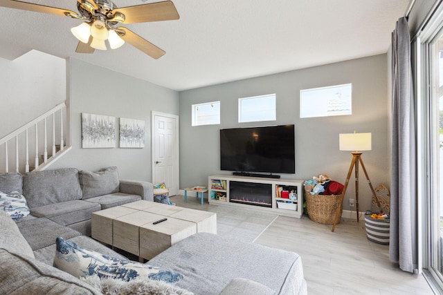 living room featuring ceiling fan and light hardwood / wood-style flooring