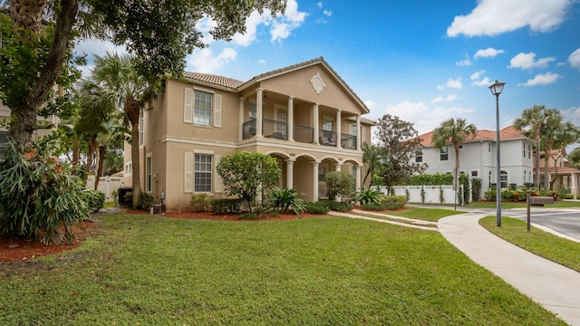 view of front of house with a balcony and a front lawn