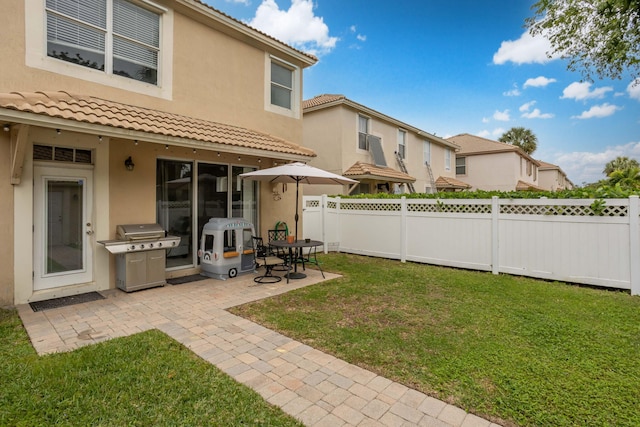 rear view of property featuring a lawn and a patio area