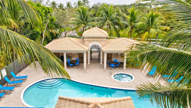 view of pool featuring a hot tub and a patio