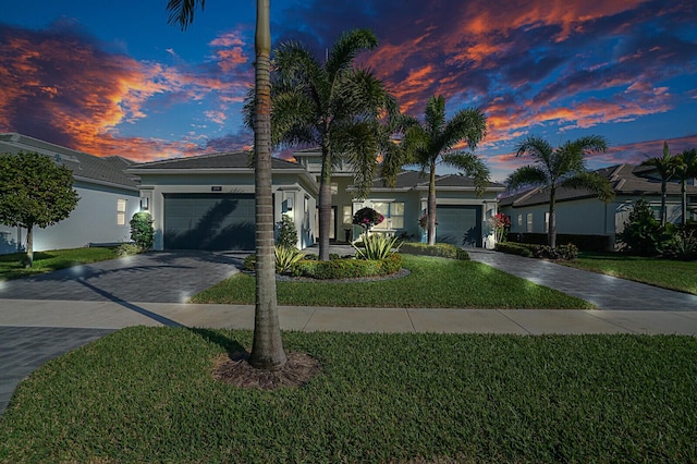 ranch-style house with a garage and a lawn