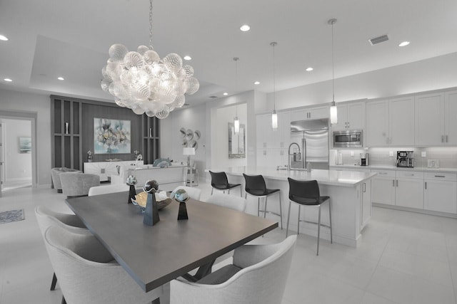 tiled dining room with sink and a chandelier