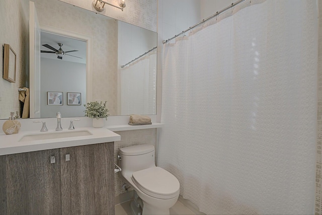 bathroom with toilet, vanity, and ceiling fan