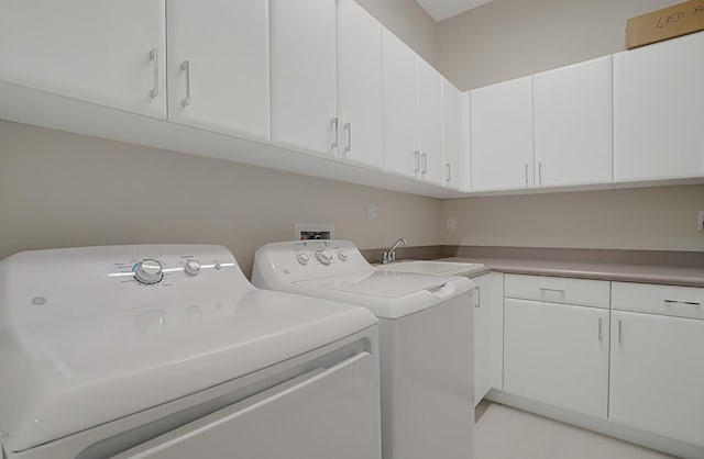 washroom with sink, cabinets, and washer and dryer