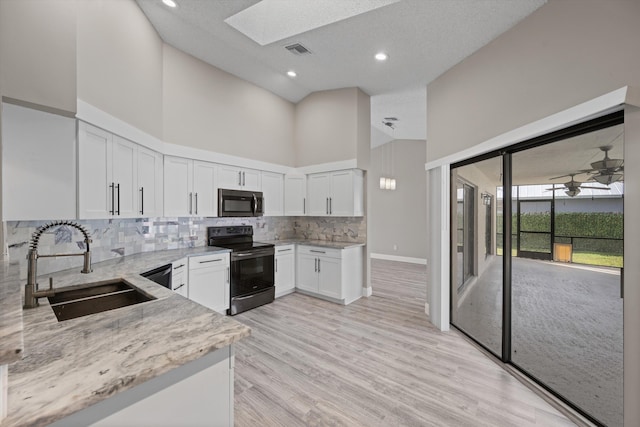 kitchen with light stone countertops, sink, white cabinetry, high vaulted ceiling, and black electric range oven