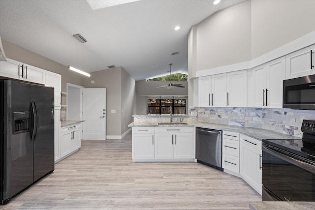 kitchen with kitchen peninsula, white cabinetry, and black appliances