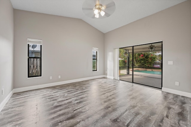 spare room featuring hardwood / wood-style flooring, plenty of natural light, ceiling fan, and vaulted ceiling