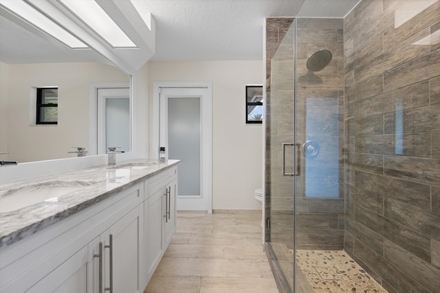 bathroom with vanity, toilet, and an enclosed shower