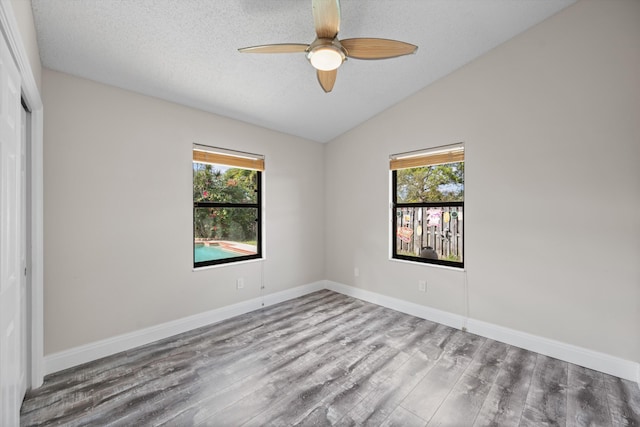 unfurnished room featuring a textured ceiling, light hardwood / wood-style flooring, ceiling fan, and lofted ceiling