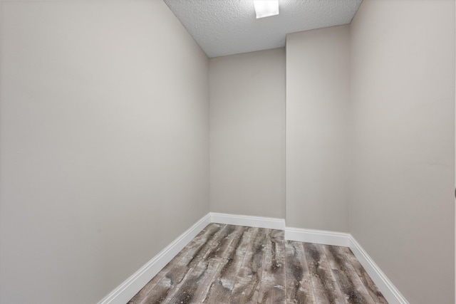 spare room featuring hardwood / wood-style floors and a textured ceiling