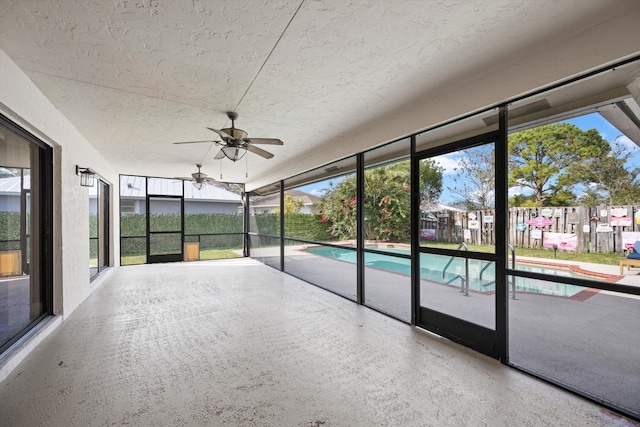 unfurnished sunroom with a wealth of natural light and ceiling fan