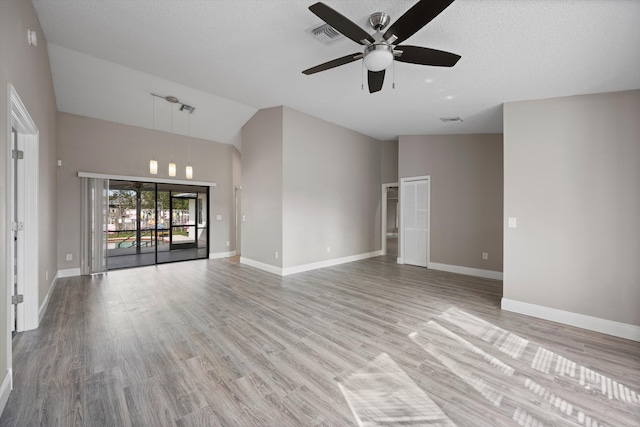 unfurnished living room with ceiling fan, light wood-type flooring, a textured ceiling, and high vaulted ceiling