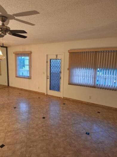 foyer entrance featuring ceiling fan and a textured ceiling