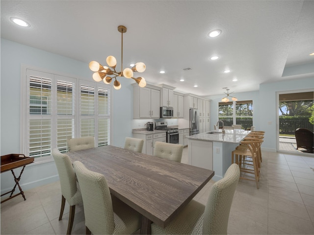 tiled dining space with sink and a chandelier