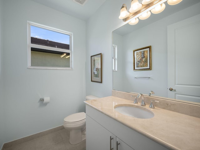 bathroom featuring tile patterned floors, toilet, vanity, and an inviting chandelier