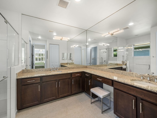 bathroom with tile patterned floors, walk in shower, and vanity