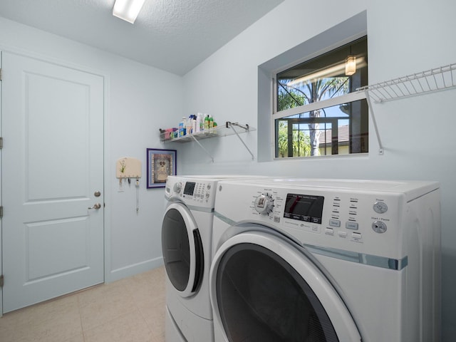 laundry room with independent washer and dryer and a textured ceiling