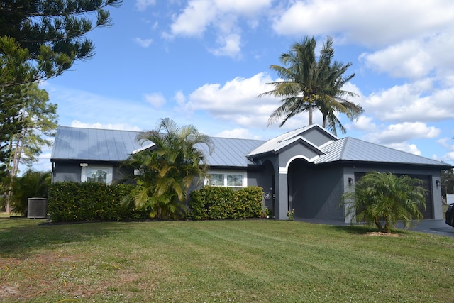 view of front facade featuring central AC unit, a garage, and a front yard