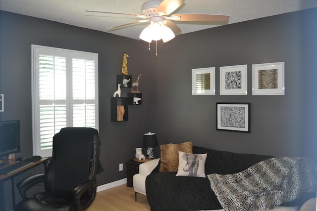 office space featuring a textured ceiling, ceiling fan, and light hardwood / wood-style floors