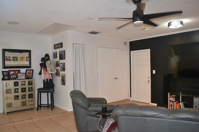 tiled living room with ceiling fan, crown molding, and a textured ceiling