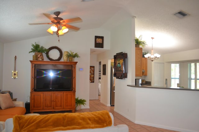 tiled living room featuring vaulted ceiling, a textured ceiling, and ceiling fan with notable chandelier