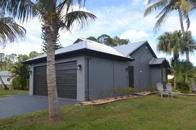 view of side of property featuring a garage and a yard