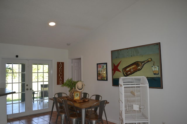 tiled dining area with lofted ceiling and french doors