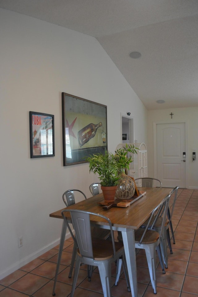 dining room with tile patterned flooring and lofted ceiling