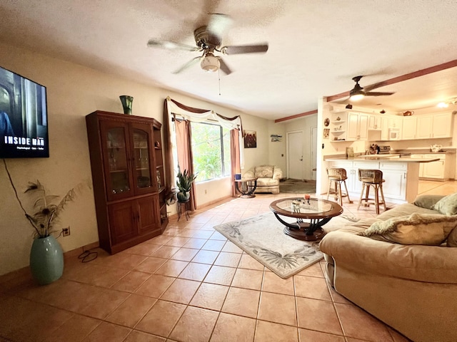 tiled living room with ceiling fan and a textured ceiling