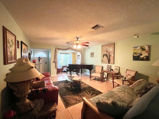 tiled living room featuring ceiling fan and a textured ceiling